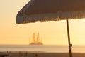 Dutch coast with industrial barge in background umbrella in foreground Royalty Free Stock Photo