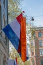 Dutch flag against a medieval facade from a house in Amsterdam the Netherlands at kings day Royalty Free Stock Photo