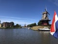 Dutch flag and windmills around the canal Royalty Free Stock Photo