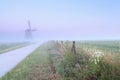 Dutch foggy farmland with windmill Royalty Free Stock Photo