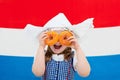 Dutch girl with orange donuts and Netherlands flag