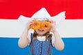 Dutch girl with orange donuts and Netherlands flag