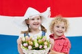 Dutch kids with tulip flowers and Netherlands flag