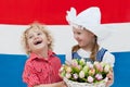 Dutch kids with tulip flowers and Netherlands flag