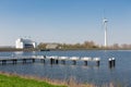 Dutch lake IJsselmeer near Medemblik with sluice windturbine and jetty