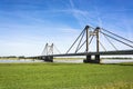 Dutch landscape with bridge over the river Waal in the Netherlands, with blue sky and green meadows Royalty Free Stock Photo