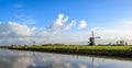 Dutch landscape with windmills along a reflecting canal Royalty Free Stock Photo