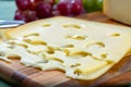 Dutch Maasdam hard cheese with holes, piece and sliced, served outdoor in green garden Royalty Free Stock Photo