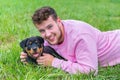 Dutch man lying with rottweiler puppy in grass Royalty Free Stock Photo