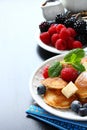 Dutch mini pancakes called poffertjes with berries Royalty Free Stock Photo