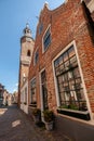 Dutch narrow street with old facades and church tower Royalty Free Stock Photo