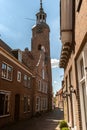 Dutch narrow street with old facades and church tower Royalty Free Stock Photo