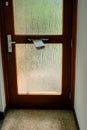 Bennekom, Netherlands,June 30,2020:Dutch newspaper hanging in door mailbox. Old brown door with glass and in door