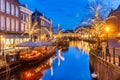 The Dutch Oude Rijn canal with bridge, historic buildings and christmas lights in the city center of Leiden Royalty Free Stock Photo