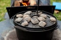 Dutch oven camp cooking with coal briquettes beads on top. Campfire Royalty Free Stock Photo