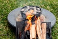 Dutch oven camp cooking with coal briquettes beads on top. Campfire Royalty Free Stock Photo