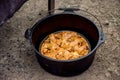 Dutch oven campfire cooking - baking an apple pie in cast iron camp oven Royalty Free Stock Photo