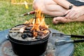 Dutch oven campfire cooking with coal briquettes beads and flame on top, Camping life