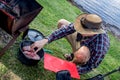 Dutch oven campfire cooking process. A man put lamb shoulders in a cast iron camp oven. Royalty Free Stock Photo