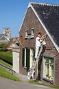 Dutch painter stands on ladder painting eaves