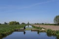 Dutch polder landscape with a water management construction early in the morning on a sunny day in the spring season Royalty Free Stock Photo