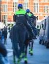 Dutch police squad formation and horseback riding mounted police back view with