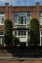 dutch street village architecture house bush places europe brick neighbourhood facade white windows doors brown roof estate Royalty Free Stock Photo