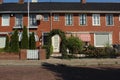 dutch street village architecture house bush places europe enter neighbourhood facade white windows doors roof pavement sidewalk Royalty Free Stock Photo