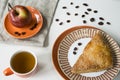 Dutch traditional food appelflap, apple turnover,  with orange cup and saucer. white and red  background Royalty Free Stock Photo