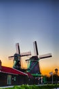 Dutch Travel Concepts. Two Traditional Dutch Windmills in the Village of Zaanse Schans at Daytime in the Netherlands Royalty Free Stock Photo