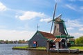 Dutch typical landscape. Traditional old dutch windmill against blue cloudy sky in the Zaanse Schans