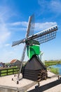 Dutch typical landscape. Traditional old dutch windmill against blue cloudy sky in the Zaanse Schans village, Netherlands. Famous Royalty Free Stock Photo