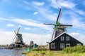 Dutch typical landscape. Traditional old dutch windmills against blue cloudy sky in the Zaanse Schans village, Netherlands. Famous Royalty Free Stock Photo