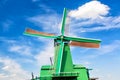 Dutch typical landscape. Traditional old dutch windmill against blue cloudy sky in the Zaanse Schans village, Netherlands. Famous Royalty Free Stock Photo