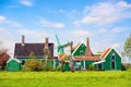 Dutch typical landscape. Traditional old dutch windmill with old houses against blue cloudy sky in the Zaanse Schans village, Neth Royalty Free Stock Photo