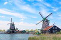 Dutch typical landscape. Traditional old dutch windmills against blue cloudy sky in the Zaanse Schans village, Netherlands. Famous Royalty Free Stock Photo