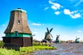 Dutch typical landscape. Traditional old dutch windmills against blue cloudy sky in the Zaanse Schans village, Netherlands. Famous Royalty Free Stock Photo