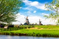 Dutch typical landscape. Traditional old dutch windmills with blue cloudy sky in the Zaanse Schans village, Netherlands. Famous