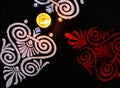 Dutch view of glowing diya and red white rangoli on black background. diwali concept Royalty Free Stock Photo