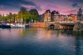 Dutch water canals with moored boats at sunset, Amsterdam, Netherlands