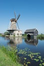 Dutch windmill at a canal on a sunny summer day