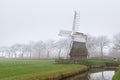Dutch windmill in fog Royalty Free Stock Photo