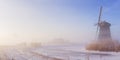 Dutch windmill in a foggy winter landscape in the morning