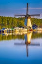 Dutch Windmill In Front of The Canal With Moored Motorboats Located in Traditional Village in The Netherlands. Shot at Kinderdijk Royalty Free Stock Photo