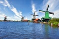 Dutch windmill in green countryside close to Amsterdam, Netherlands, with blue sky and river water