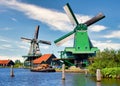 Dutch windmill in green countryside close to Amsterdam, Netherlands, with blue sky and river water