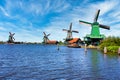 Dutch windmill in green countryside close to Amsterdam, Netherlands, with blue sky and river water