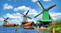 Dutch windmill in green countryside close to Amsterdam, Netherlands, with blue sky and river water