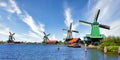 Dutch windmill in green countryside close to Amsterdam, Netherlands, with blue sky and river water