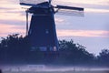 Dutch windmill in misty countryside